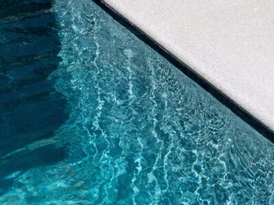 Crystal clear residential swimming pool showing the benefits of regular professional pool cleaning and maintenance