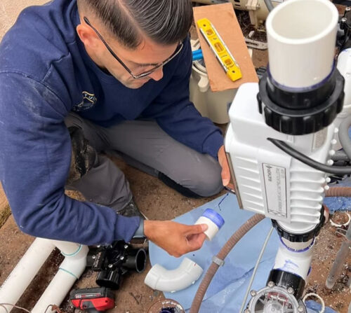 Technician installing a residential pool chlorinator system in Melbourne