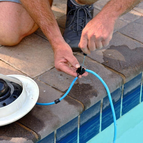 Technician connecting pool light wiring during pool lighting installation in Melbourne
